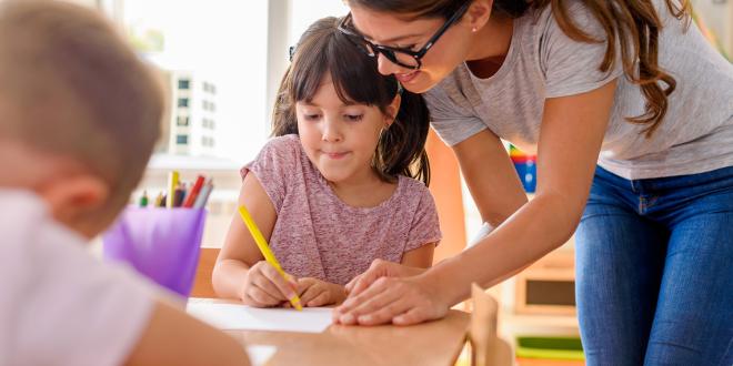 a girl getting help from her teacher in class